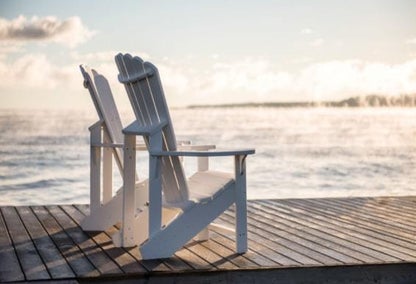 Muskoka chairs on a dock over looking lake Huron