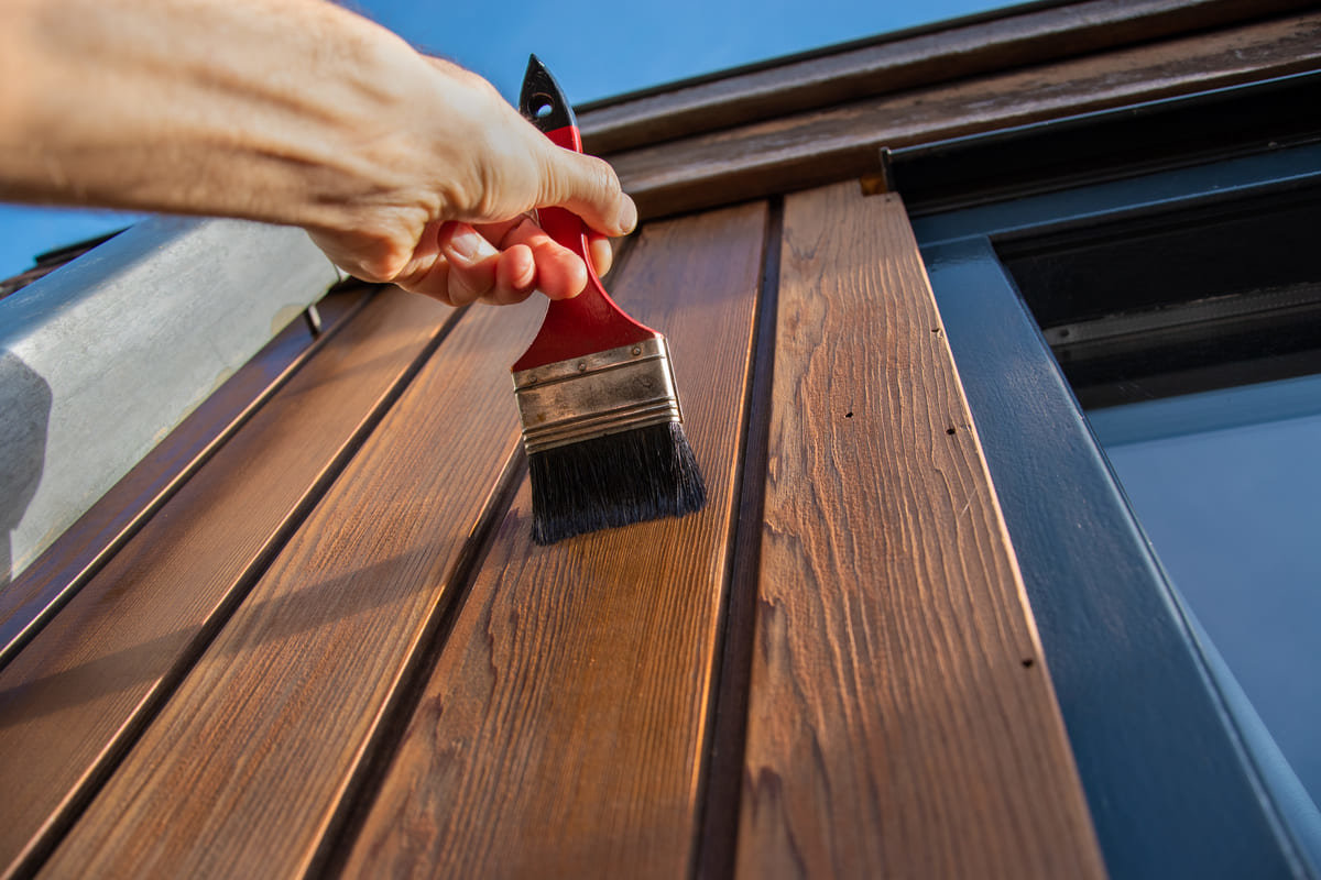 Applying a weather-resistant sealant on wood.