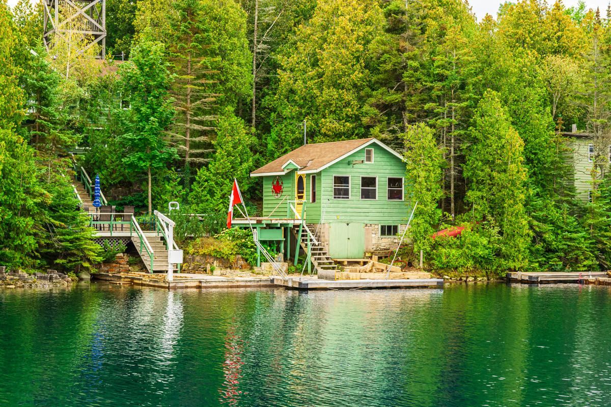 A green Muskoka cottage during the day.