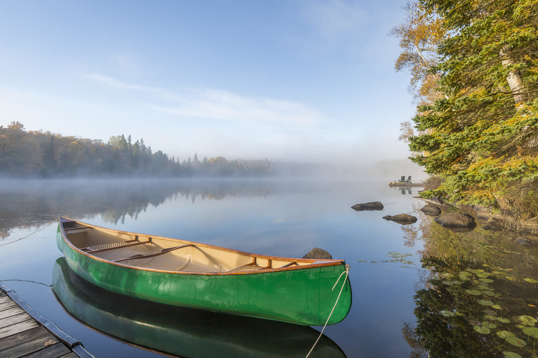 A canoe sitting by a dock in Muskoka, Ontario