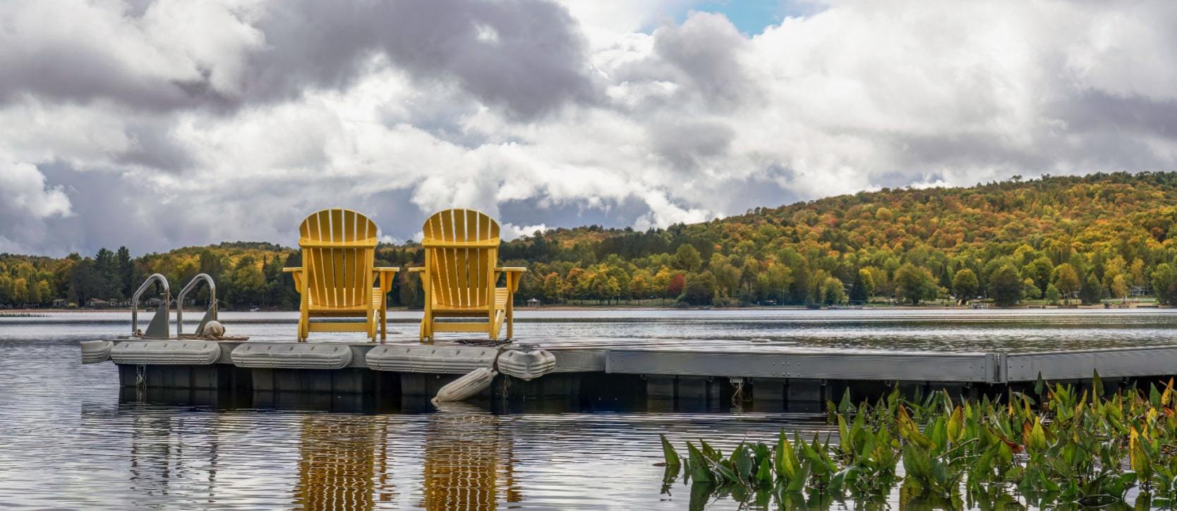 Chairs on a dock in front of the water in the Algonquin Highlands, Haliburton