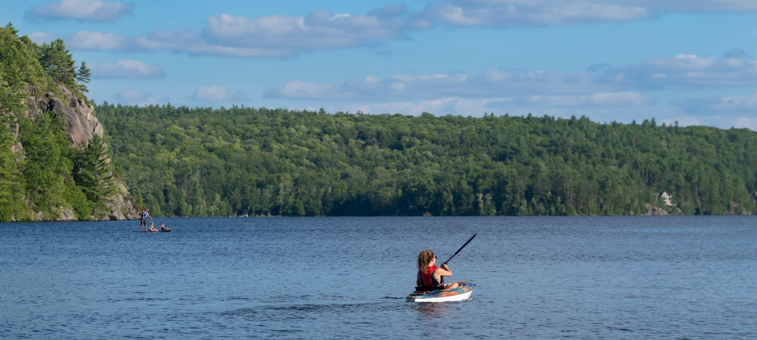 Person kayaking on a Muskoka Lakes region lake