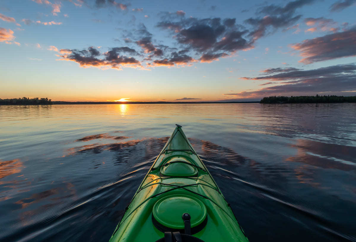 A person in a kayak at dawn.