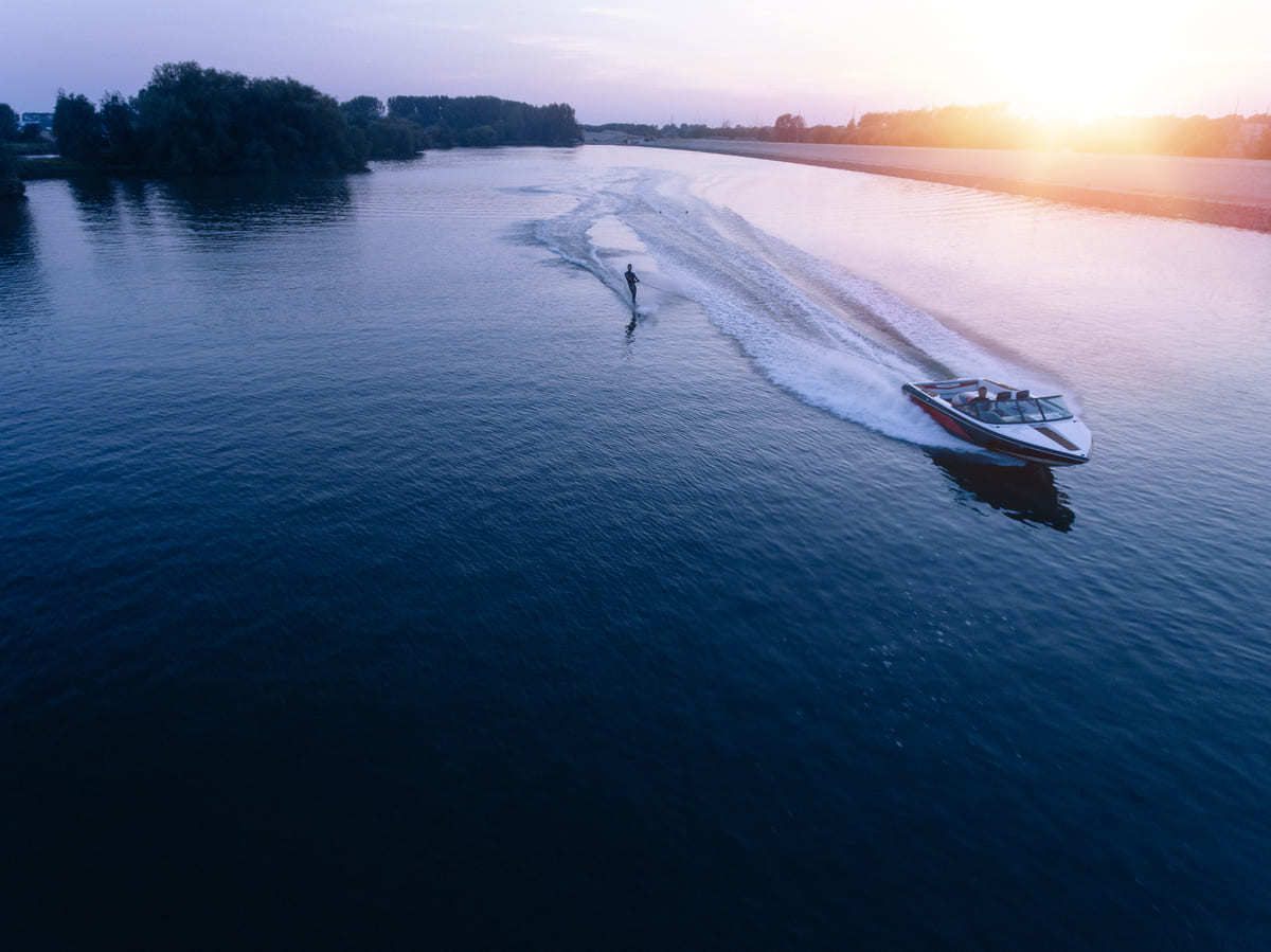 An aerial view of a boat pulling a water skiier.
