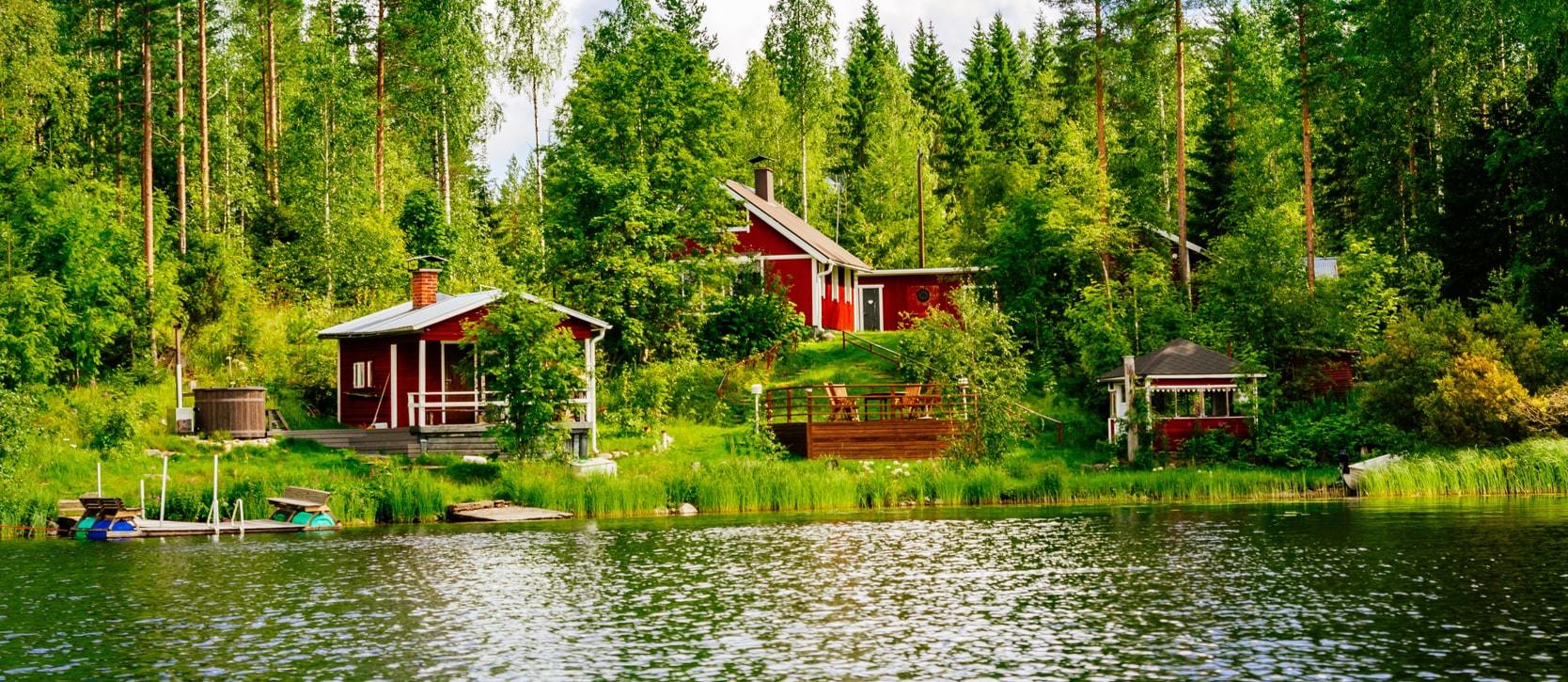 Beautiful view of a cottage home sitting at the edge of a shining lake 